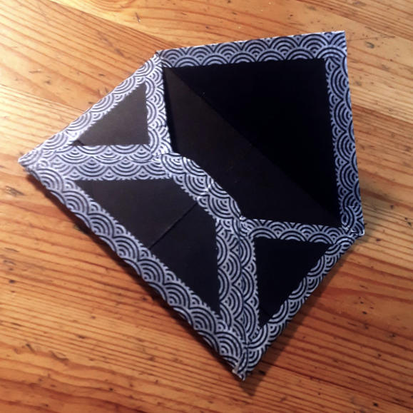Photo d'une petite enveloppe fait-main en papier noir et masking-tape à motifs japonais